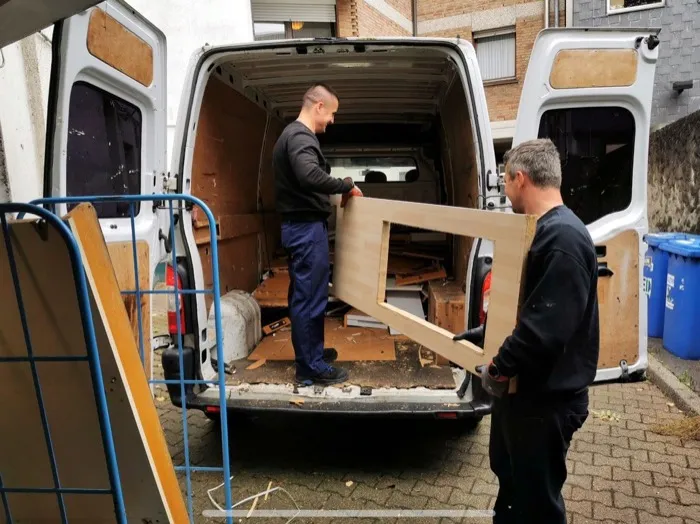Mitarbeiter der Ausmister laden Möbel in den Transporter